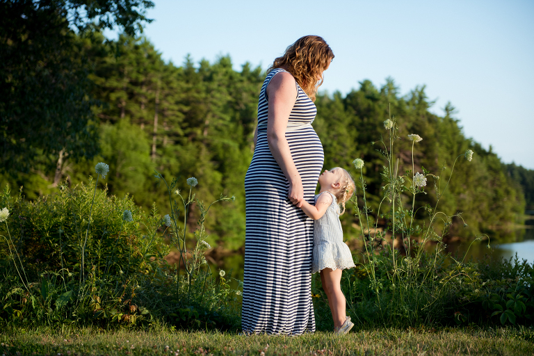 young-daughter-looking-up-at-pregnant-mom-maine-family-photographer