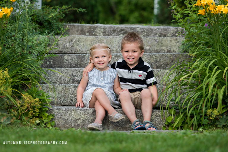 young-brother-and-sister-posing-on-stone-steps-maine-family-photographer