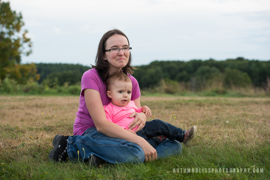 mother-sitting-in-field-with-young-daughter