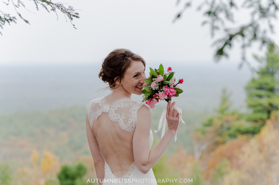 bride-smelling-flowers-at-summit-of-mount-agamenticus-york-maine