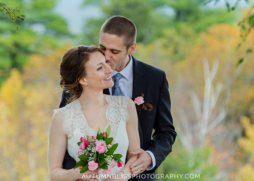 groom-kissing-bride-in-maine-fall-foliage