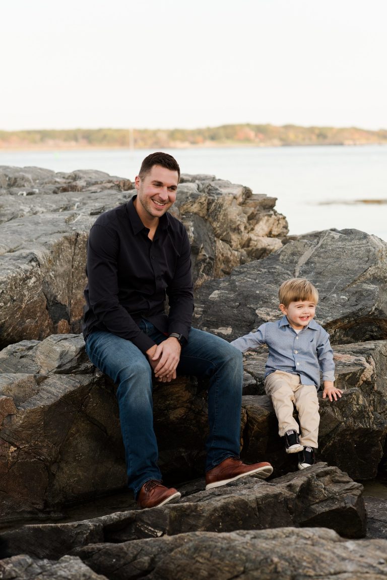 father-son-sitting-on-beach-rocks