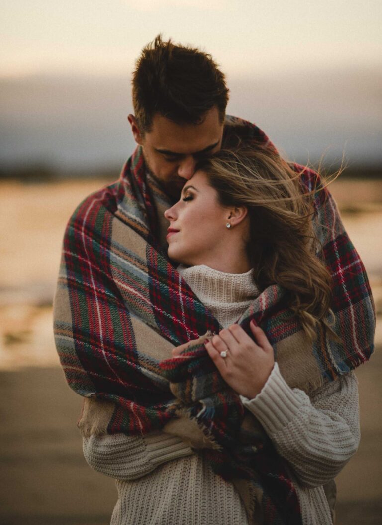couple-snuggling-moody-beach