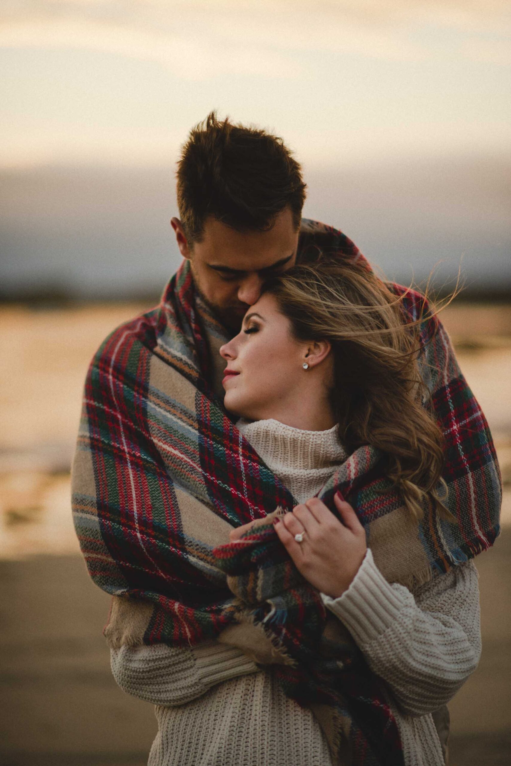 couple-snuggling-moody-beach